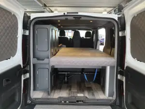 Fahrzeugumbau Renault Trafic Camper Bett ausgeklappt Heckansicht